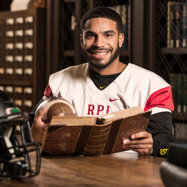 Student football player reading a historical book in the Archives
